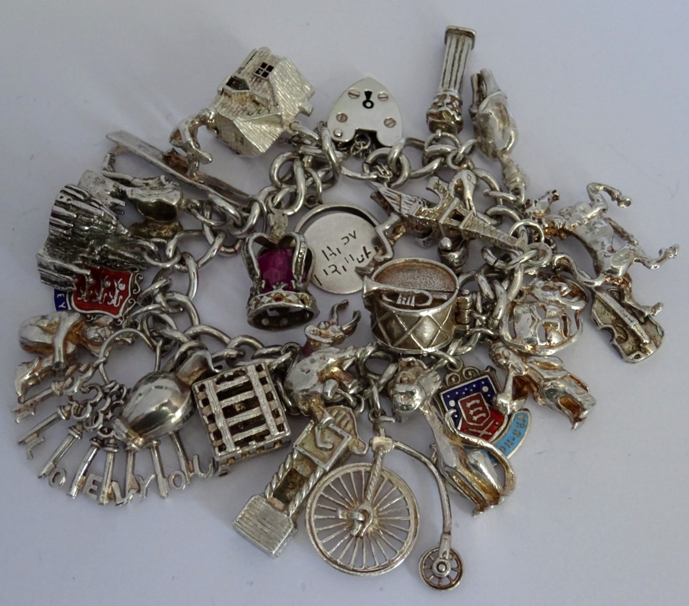 Vintage heavy solid silver charm bracelet &many curious silver charms inc moving
