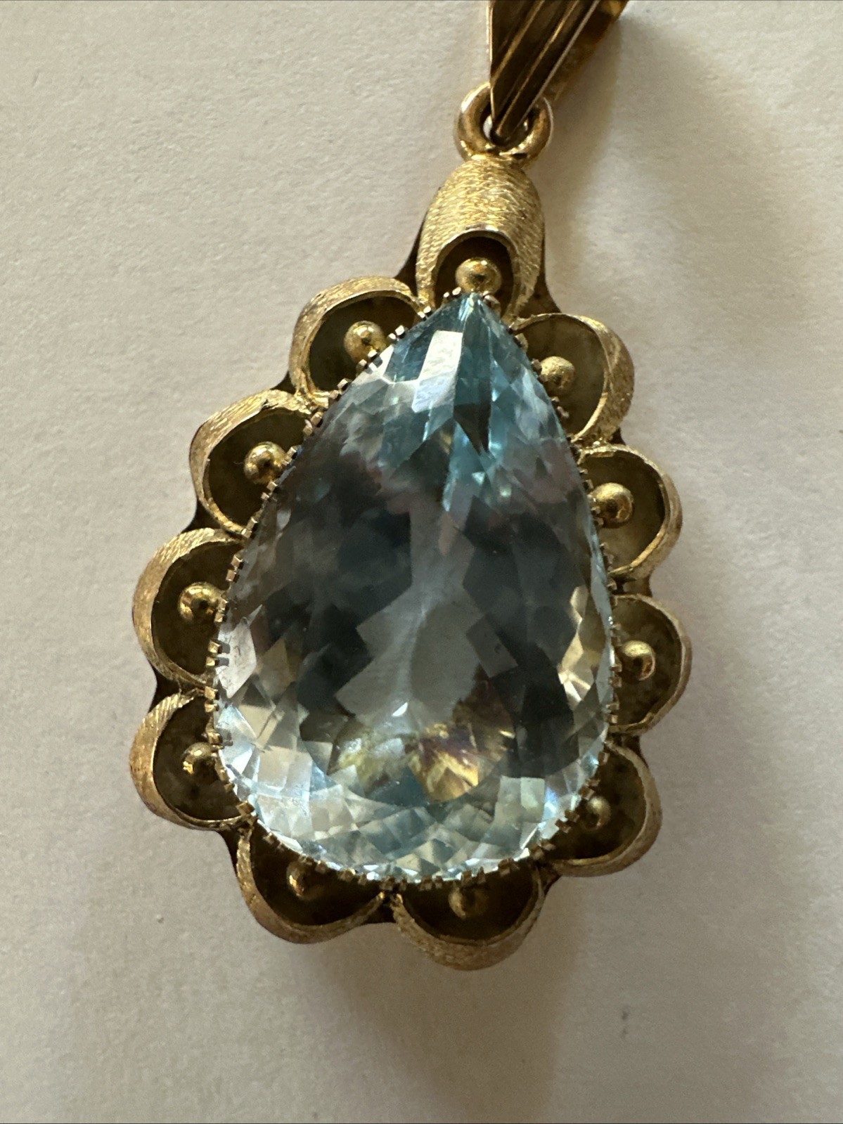 Vintage 14K yellow gold pendant featuring a large pear-cut light blue Topaz